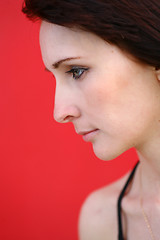 Image showing girl is posing against red wall