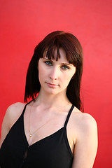 Image showing girl is posing against red wall