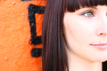 Image showing girl is posing against orange wall