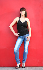 Image showing girl is posing against red wall