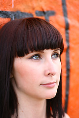 Image showing girl is posing against orange wall