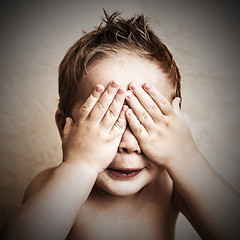 Image showing Portrait of little boy closed eyes with his hands