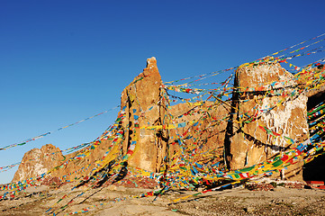 Image showing Huge rocks wrapped with colorful prayer flags