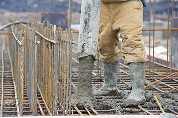 Image showing builder worker pouring concrete into form