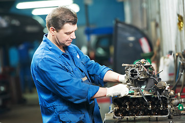 Image showing auto mechanic at repair work with engine