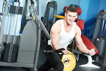 Image showing bodybuilder man doing exercises in fitness club