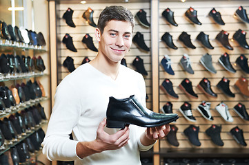 Image showing Young man at choosing shoe in clothes store