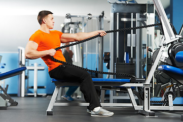 Image showing bodybuilder man doing exercises in fitness club