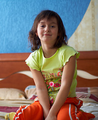 Image showing Young girl sitting on bed