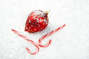 Image showing Candy Canes and Ornament lying in the snow