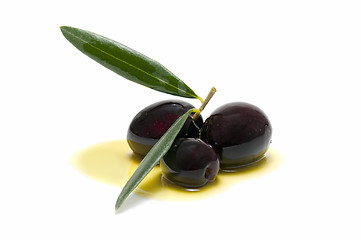 Image showing three fresh olives bathed in olive oil