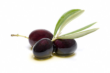 Image showing three fresh olives bathed in olive oil