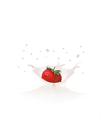 Image showing Strawberry falls into milk causing splash and drops