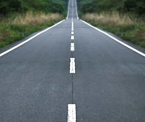 Image showing Straight tar road leading into the light