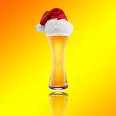 Image showing Santa Claus hat with beer on a yellow background