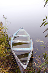 Image showing Sunken wooden boat with water stand on river shore 