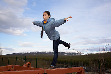 Image showing girl doing gymnastic element of the balance on a log