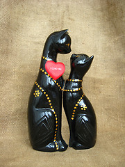 Image showing Two toy enamoured cats on a brown background