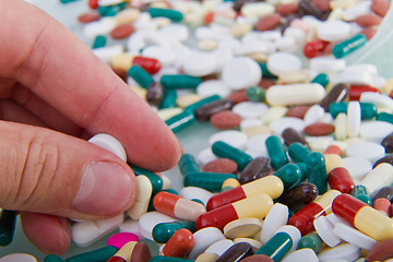 Image showing hand grabbing pills