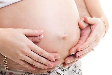 Image showing Caring hands of parents embracing tummy of pregnant mother