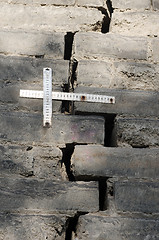 Image showing Rulers measuring the cracks in the brick wall