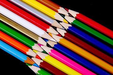 Image showing Assortment of coloured pencils with shadow on white/back backgro