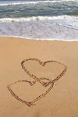 Image showing handwritten heart on sand with wave approaching