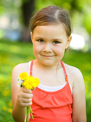 Image showing Little girl with a bunch of dandelions