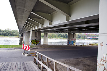 Image showing road sign direction under large river bridge 