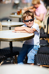 Image showing Boy sitting in outdoor cafe 