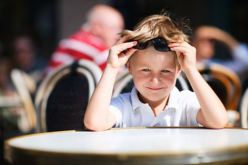 Image showing Boy sitting in outdoor restaurant