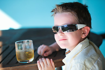 Image showing Stylish little boy drinking juice