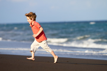 Image showing Boy running at black sand beach