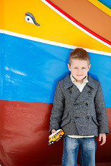 Image showing Boy near colorful boat