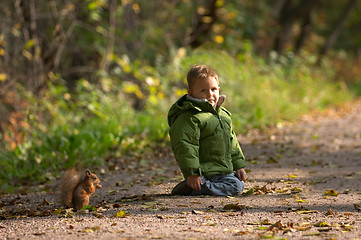 Image showing Little boy and squirrel