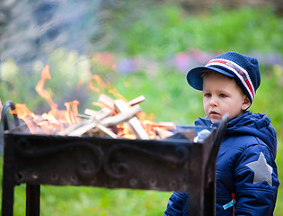 Image showing Boy looking to fire