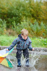 Image showing Boy jumping in puddle