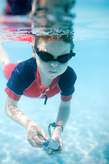 Image showing Little boy swimming underwater