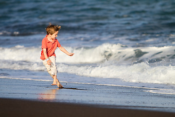 Image showing Kid runs on the beach