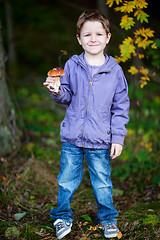 Image showing Boy with wild mushroom in forest