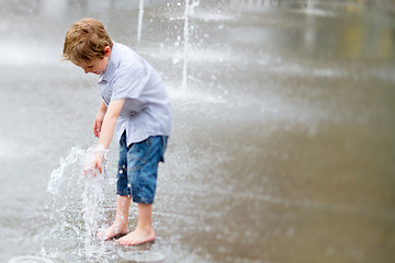 Image showing Cute little boy playing with water outdoors