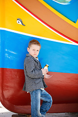 Image showing Boy near colorful boat