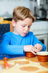 Image showing Cute boy making cupcakes