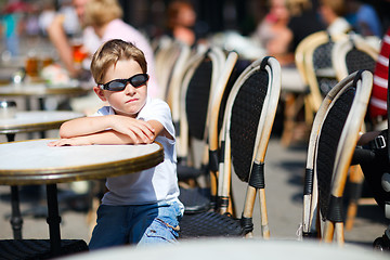 Image showing Cute boy sitting in outdoor cafe