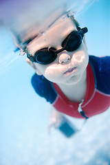 Image showing Little boy swimming underwater