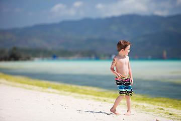 Image showing Little boy standing by ocean shore