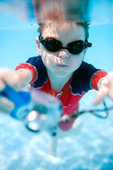 Image showing Little boy swimming underwater