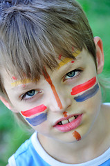 Image showing football fan child with painting on his face 