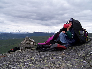 Image showing Boy drinking water on cloudy day in the mountains