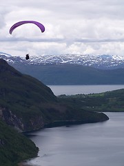 Image showing Paraglider over water with mountains